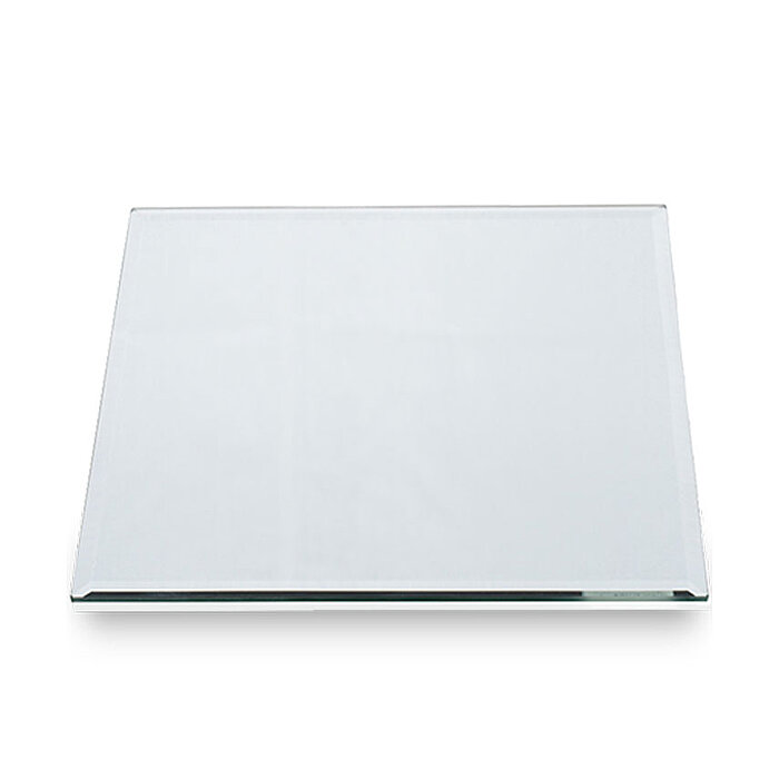 Eine quadratische, glatte Glasplatte mit abgeschrägten Kanten liegt auf einer weißen, ebenen Fläche. Die Transparenz und Klarheit des Glases lassen das Bild minimalistisch und rein wirken.