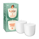 Zwei Cleanlight Duftkerzen-Nachfüller mit Bergamotte/Neroli-Duft stehen neben der dazugehörigen grünen Verpackung mit Bolsius Schriftzug.