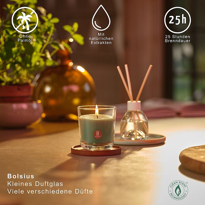 Ein brennendes Duftglas von Bolsius auf einem Tisch zwischen Kräutern. Auf dem Bild werden verschiedene Vorteile des Duftglases hervorgehoben und die Brenndauer von 25h dargestellt.