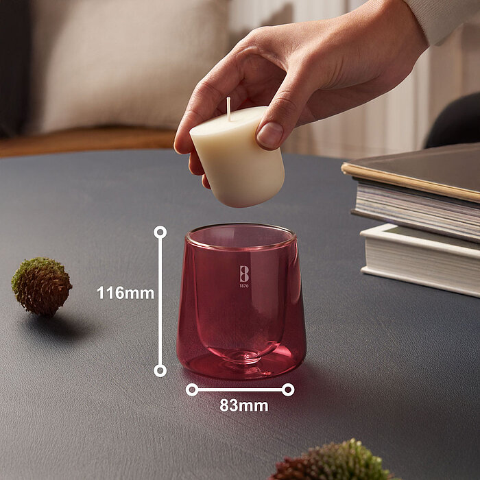 Eine Hand bestückt ein pinkes Bolsius Cleanlight Duftglas mit einem Nachfüller mit Zedernholz  und Vetiver-Duft.