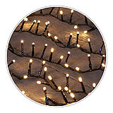 Mehrere Reihen von warmweiß leuchtenden LED-Lichterketten, die auf einem dunklen Holzuntergrund diagonal angeordnet sind. Die Lichter erzeugen eine gemütliche und festliche Atmosphäre.
