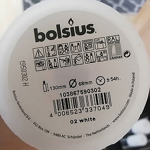Nahaufnahme der Unterseite einer Kerze von Bolsius, auf der Abbrandhinweise und Piktogramme zu sehen sind.